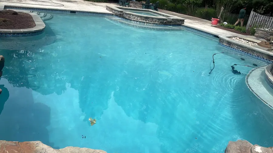 Clear blue backyard swimming pool after weekly pool service